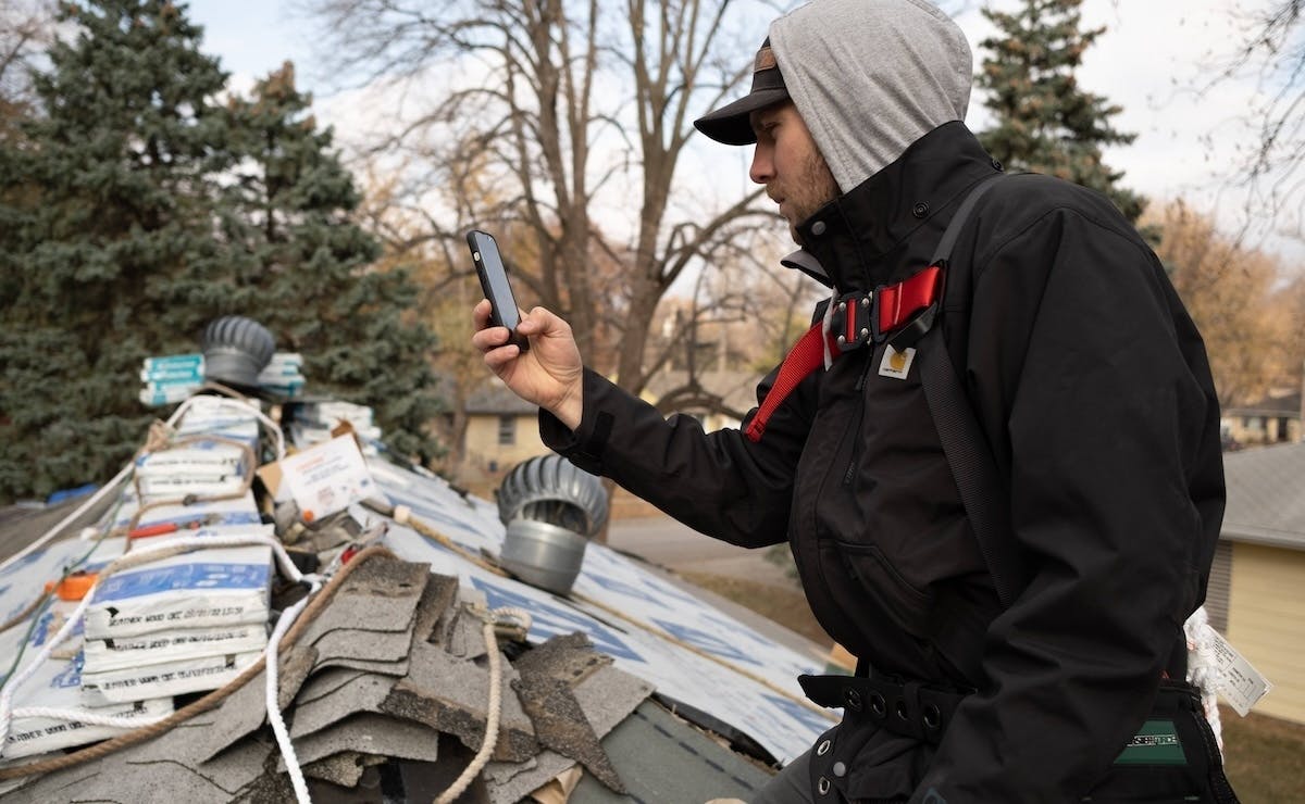 Field technician documenting a job site with their phone.