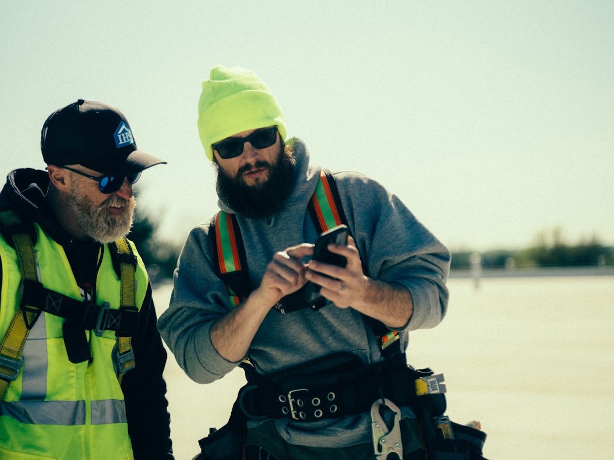 Crew reviews job site photos in construction documentation app.