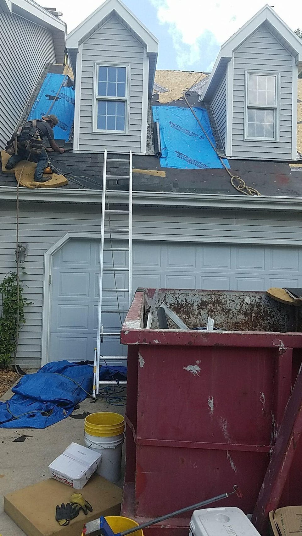 dumpster-at-side-of-house-with-ladder-companycam-photo
