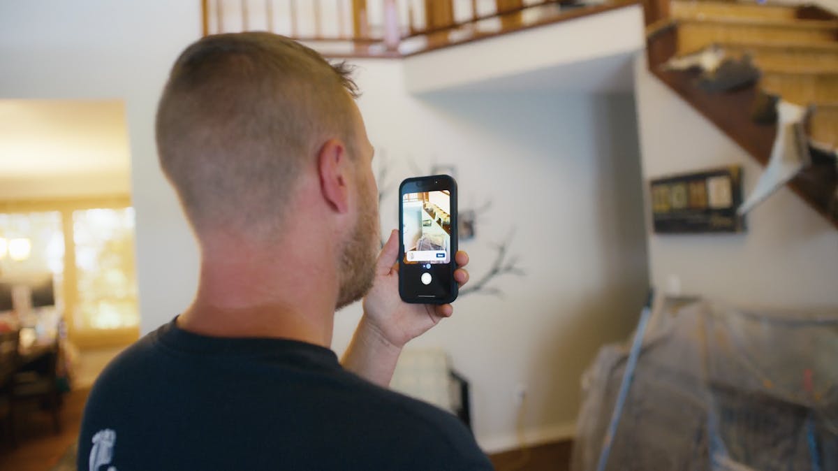 Crew leader using mobile app construction software to record jobsite progress