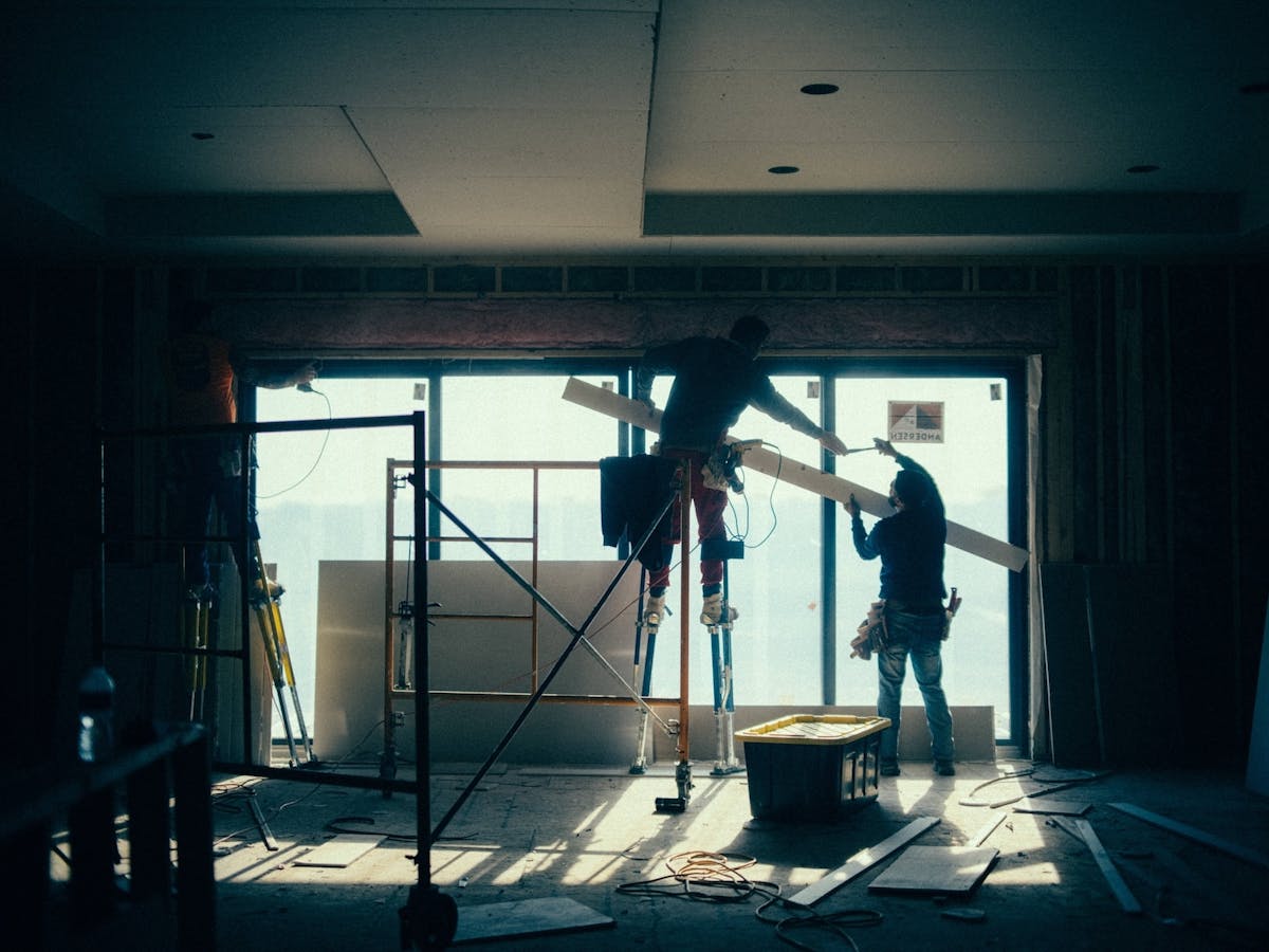 construction workers install drywall or insulation inside a building under renovation