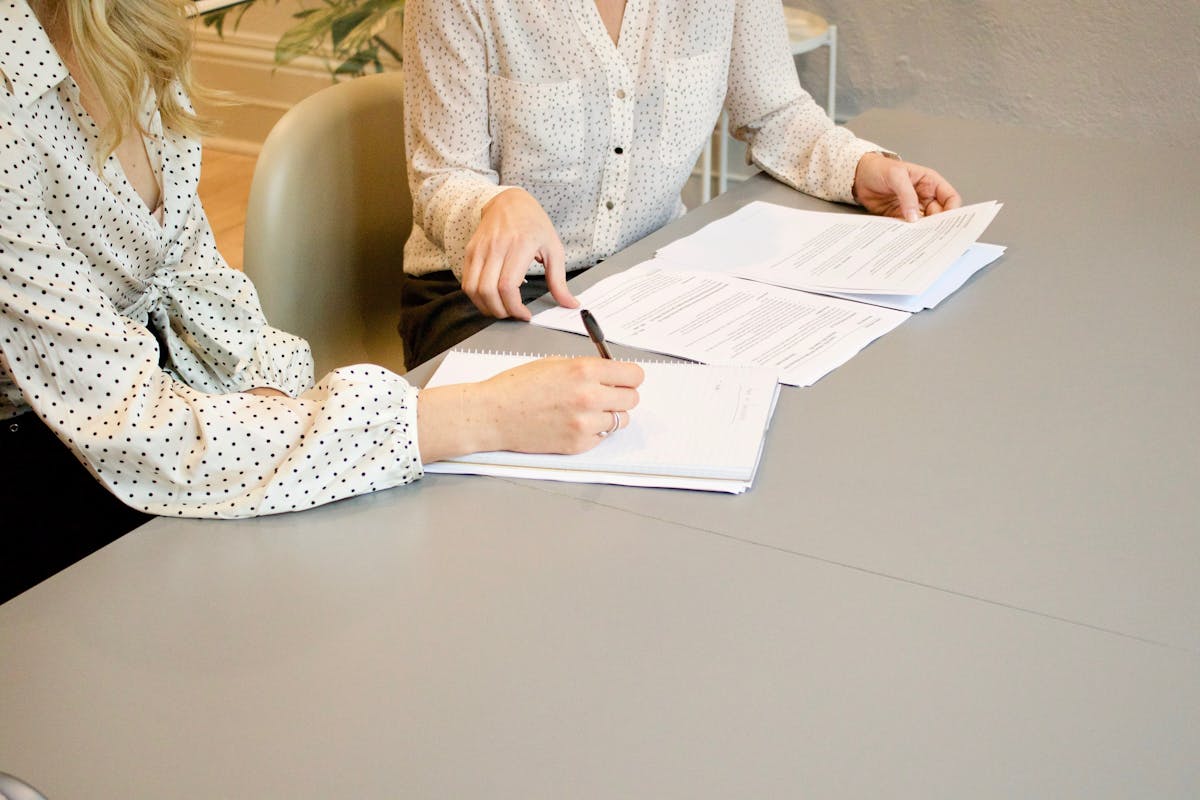 Office staff review signed job documents to verify scope, approvals, and change orders.