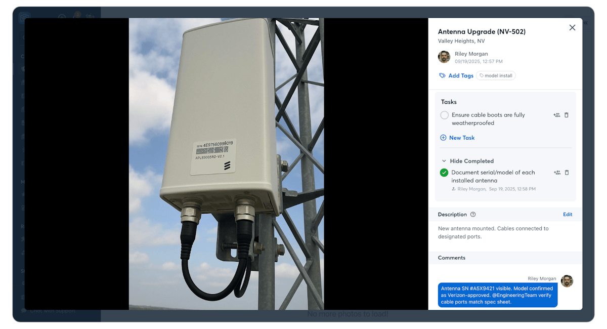 Newly installed 5G antenna showing serial number and model label on tower mount; crew completes documentation task using CompanyCam and confirms model is approved with correct cable port match.